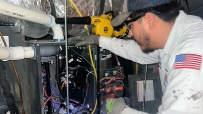 A tech working on an air conditioning unit.